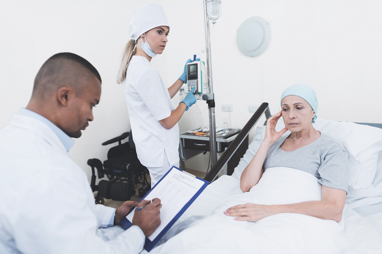 A nurse and doctor checking on a patient after chemotherapy
