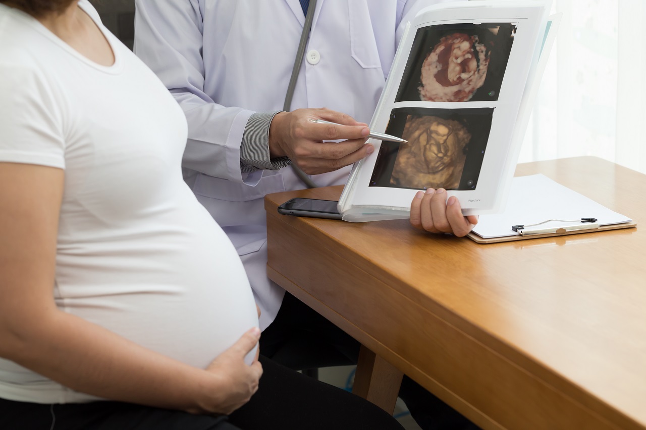 A doctor talking to a pregnant woman about her baby