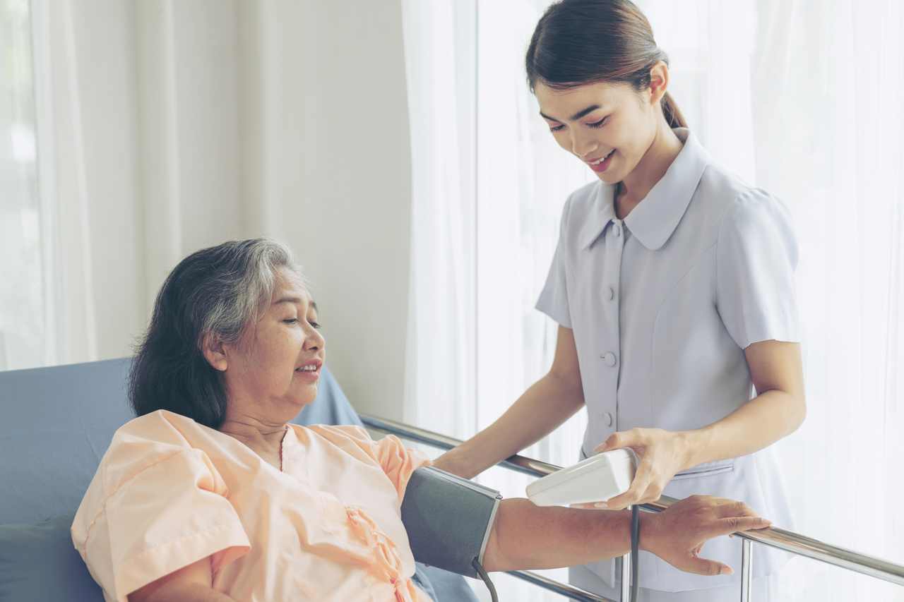 A nurse taking the blood pressure of a female patient
