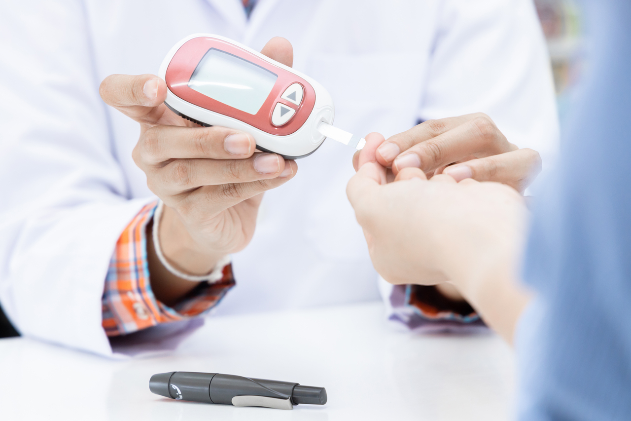 Doctor checking blood glucose level for insulin determination in patient